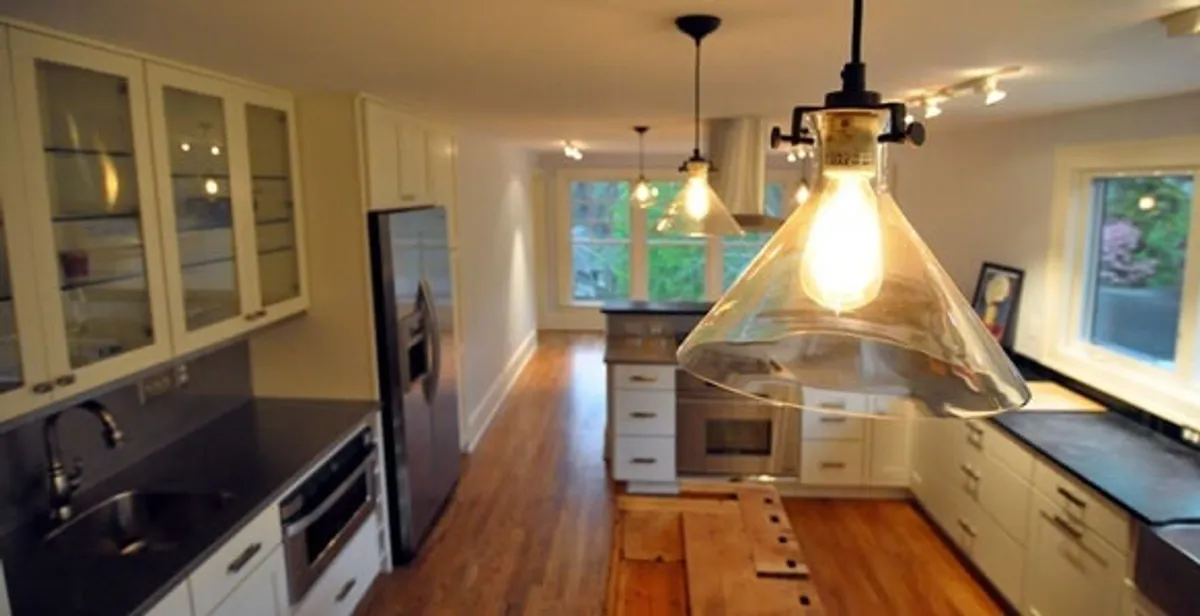 Residential electrician installing modern indoor light fixture in a home in Richmond, VA
